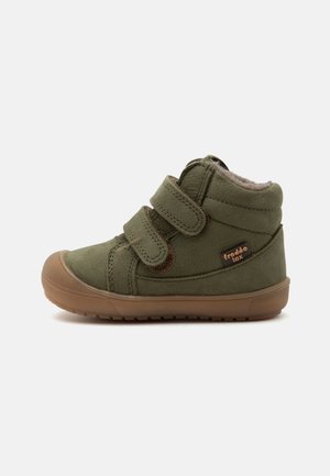 Child's olive green ankle boot with brown sole, two Velcro straps, soft inner lining, and "froddo tex" label on the side.
