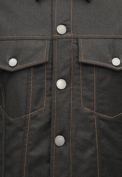 Jachetă din denim negru cu două buzunare la piept, închideri cu butoni arginti și cusături contrastante portocalii. Textură netedă.