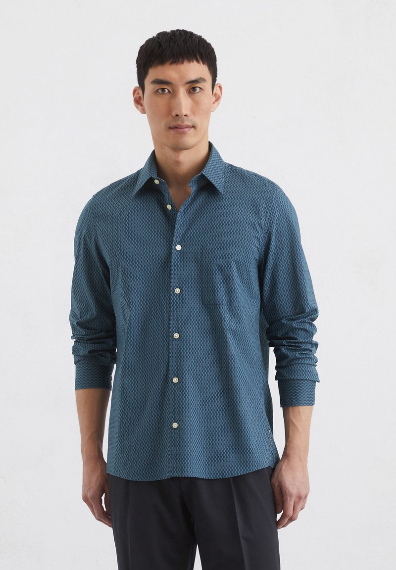 Teal gemusterde knoopshirts met een gestructureerde kraag, lange mouwen en manchetfaciliteiten. Bevat kleine beige knopen en een gestructureerde stof.