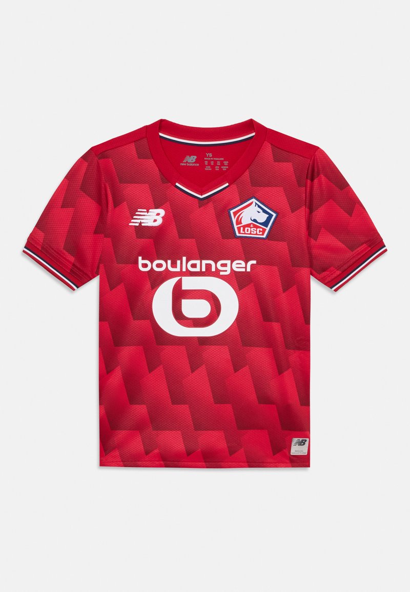 Camisola de futebol vermelha feita de tecido leve. Apresenta um decote em V, mangas curtas, padrão geométrico, logótipo da New Balance e um design circular de patrocinador.