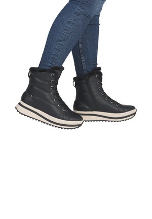 Black lace-up boots with faux fur lining, padded design, and a thick white sole with black accents. Suitable for cold weather.