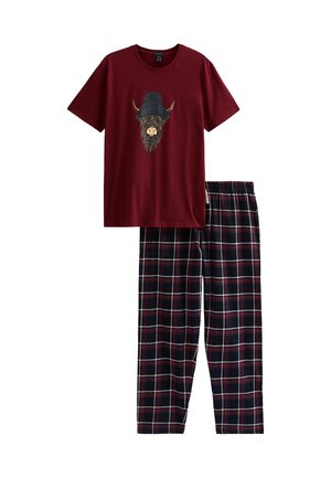 Burgundowa koszula z krótkim rękawem z górskim bydłem noszącym granatowy kapelusz z pomponem, sparowana z granatowymi, burgundowymi i białymi spodniami w kratę.