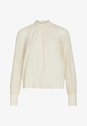 Krembluse med lange ærmer og blonde detaljer, høy nakke og knappelukking i ryggen. Glatt tekstur, avslappet passform.