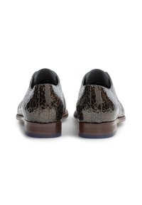 Scarpe in pelle marrone con una texture screpolata, punta arrotondata e tacco basso. Le scarpe hanno un interno liscio e una suola solida e scura.