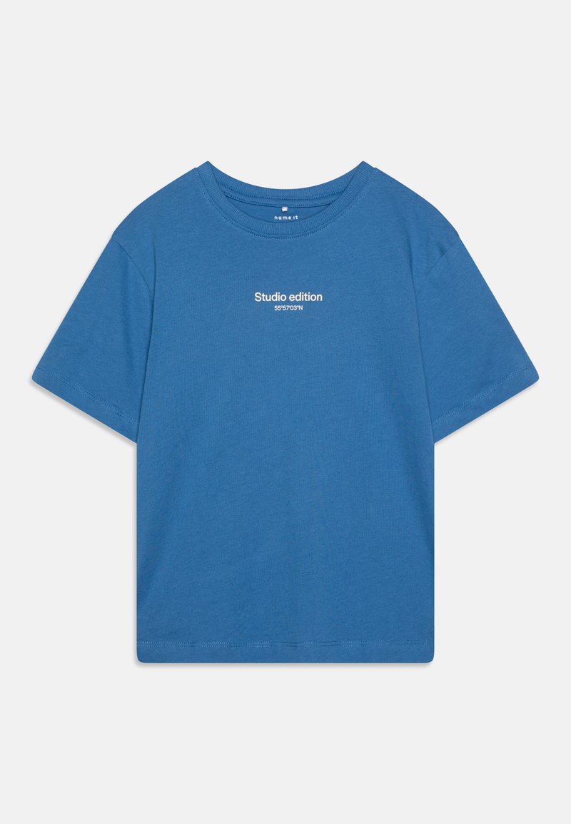 Modrá bavlnená tričko s krátkymi rukávmi, okrúhlym výstrihom a bielym textom "Studio edition" na prednej strane. Hladká textúra, štandardný strih.