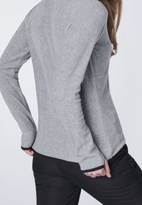 Szary długi rękaw bluzka o dopasowanym kroju, wykonana z miękkiego materiału. Posiada kontrastowe czarne wykończenie na mankietach i bezszwowy wygląd.