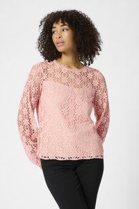 Haut à manches longues en dentelle rose avec un motif floral, col en dentelle et manches texturées. Assorti à un pantalon noir ajusté.