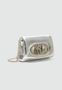 Borsa a tracolla argentata in metallo con catena, dotata di una chiusura ovale prominente e una superficie liscia e riflettente.