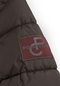 Brun puffjacka i tyg med quiltad textur. Har en vinröd badge med en logotyp och texten "POLO CLUB" i grått.