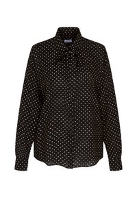 Blouse noire à manches longues avec pois blancs, boutons sur le devant, col montant et détail nœud noué au niveau du col.