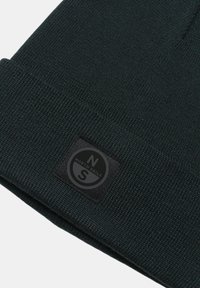 Bonnet en tricot noir avec un revers replié, présentant une étiquette rectangulaire noire avec le texte blanc "NORTH SAILS" et un logo "N". Texture douce.