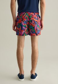 Pantalones de baño coloridos con un estampado floral tropical, fabricados en tejido ligero, con una cinturilla elástica y bolsillos laterales.