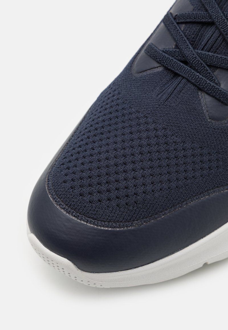 Sneaker blu navy con upper in rete dotato di perforazioni testurizzate e dettagli in pelle, suola in gomma bianca e lacci piatti blu navy.