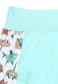 Light blue cotton shorts feature a patterned side panel with illustrations of sharks, fish, and smiling animals on a white background.