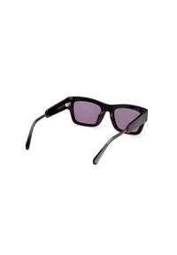 Gafas de sol de plástico negro con lentes morados, de forma rectangular y con patas rectas. Presentan una textura sutil y acentos de hardware minimalistas.