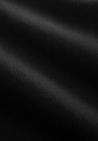 Glat sort stof med subtil diagonal vævning og blide folder, der skaber bløde skygger og højlys.