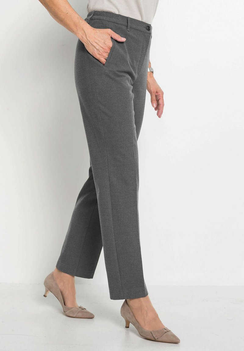 Grau maßgeschneiderte Hose mit glatter Textur, ausgestattet mit einem Bund und Seitentaschen. Kombiniert mit hellbeigen Absätzen.