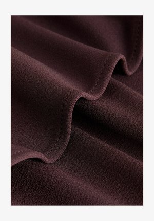 Dunkelburgunderfarbener Stoff mit einer weichen, strukturierten Oberfläche, die glatte, fließende Falten und einen sauberen Saum entlang der Kanten aufweist, ohne sichtbare Muster.