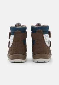 Braune High-Top-Schuhe mit strukturierten Seiten, blauen Akzenten und einem weißen Detail mit Grafiken. Klettverschlüsse für einen sicheren Sitz.