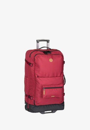 Sac à dos à roulettes rouge en tissu, avec une poignée rétractable, poche zippée à l'avant, accents noirs en bas et un écusson en logo circulaire à l'avant.