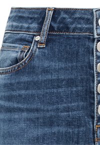 Cintura de vaqueros de mezclilla con lazo para cinturón, bolsillo frontal y fila vertical de botones plateados en el lado derecho.