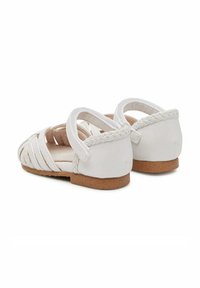 Sandali bianchi con design superiore intrecciato, suola piatta in sughero e dettagli intrecciati sul tallone. Cinghie regolabili per una vestibilità sicura.