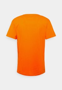 Koszulka z krótkim rękawem w jaskrawym pomarańczowym kolorze, wykonana z bawełny, z okrągłym dekoltem i gładką, jednolitą teksturą. Widok z tyłu pokazuje prosty krój.