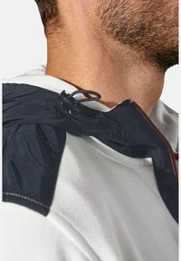 Marineblauer elastischer Kordelzug-Hoodie über einem weißen Sweatshirt. Verfügt über einen strukturierten Stoff mit kontrastierender Naht und einem Reißverschlussdetail.