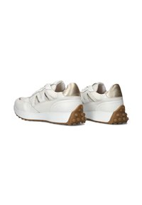 Witte en gouden sportschoenen van gestructureerd leer, met mesh-panelen, een dikke witte zool en een bruine rubberen buitenzool met zichtbare bulten.