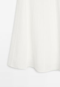 White, pleated skirt made of lightweight fabric, featuring a smooth texture and a flowing silhouette that extends to mid-calf length.