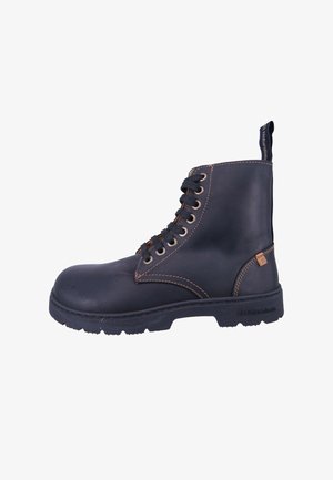 Bota de cuero negro con cordones, costuras en tono marrón, suela de goma texturizada, puntera redondeada y un lazo en el talón para facilitar su colocación.