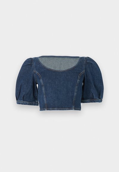 Τζιν κοντό τοπ με φουσκωτά κοντά μανίκια και φαρδιά στρογγυλή λαιμόκοψη, με ορατές ραφές για καλύτερο σχήμα.