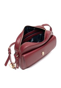 Bordowa skórzana torebka o teksturowanej powierzchni, z złotymi elementami, zamkiem błyskawicznym i przestronnym wnętrzem wykończonym ciemną, wzorzystą podszewką oraz kieszeniami.