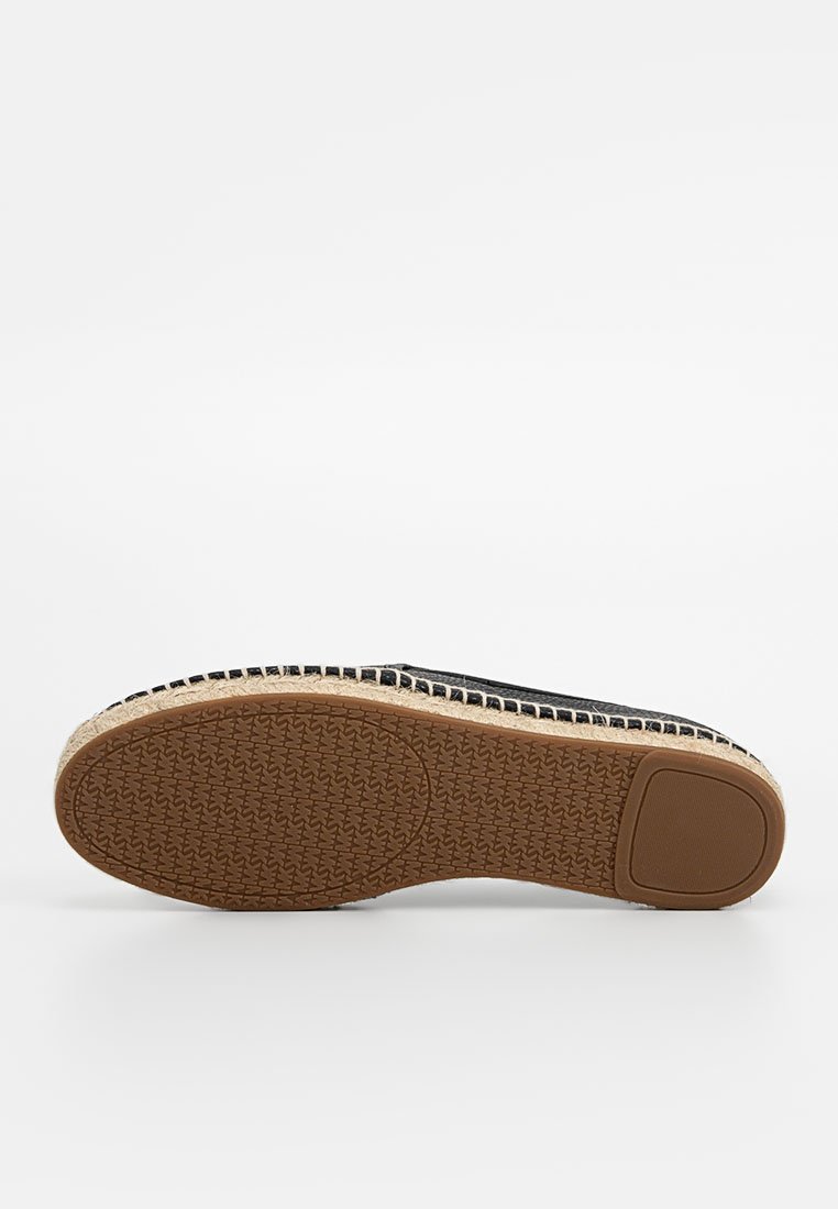 Lichte schoen met een zwarte canvas bovenkant, jute tussenzool en rubberen zool. Getextureerde onderkant voor grip, met een eenvoudig, plat ontwerp.