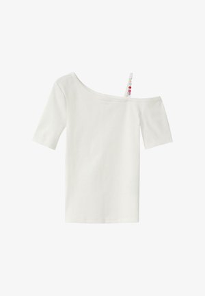 Haut blanc à manches courtes côtelé avec encolure asymétrique et une bretelle perlée sur l'épaule droite.