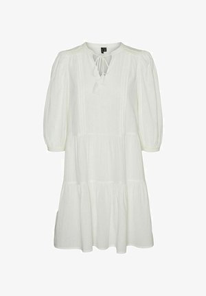 Bela, večplastna obleka ohlapnega kroja, z zaobljenim izrezom, detajlom s trakom in napihnjenimi rokavi. Narejena iz lahkotnega materiala.