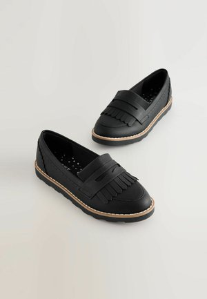 Fekete bőr mokaszinok francia jellel, kerek orral és gumitalppal. Könnyű varrás és puha, textúrált felület jellemzi őket.