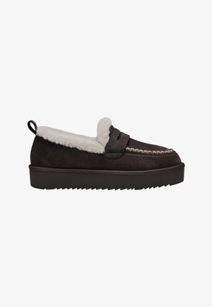 Mørkebrun slip-on loafer med hvid fluffy foring, tyk sort sål og struktureret syning langs den øverste kant og på overlæderet.