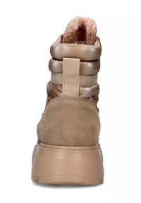 Bottes cheville marron avec un design matelassé brillant, dotées d'un talon en daim texturé et d'un intérieur doux doublé de fourrure. Comprend une languette pour faciliter l'enfilage.