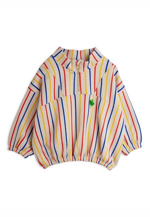 Long-sleeve cream pullover with red, blue, and yellow vertical stripes, half-zip collar, elastic cuffs and hem, and a small green clover detail.