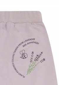 Helllilafarbene Textilie mit einer weichen Textur, die eine Grafik von Lavendel und einer Biene zeigt, mit dem Text "Pflanzenbasierte Farben aus Lavendel; von Bienen genehmigt!"