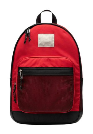 Sac à dos Herschel rouge et noir avec une poche avant en mesh zippée, deux tirettes de fermeture éclair et une poignée de transport supérieure.