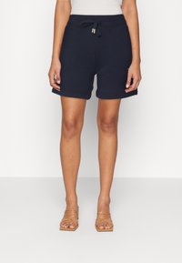 Bermudas azul marino de material suave con cintura elástica y cordón, con dobladillos enrollados y bolsillos laterales.