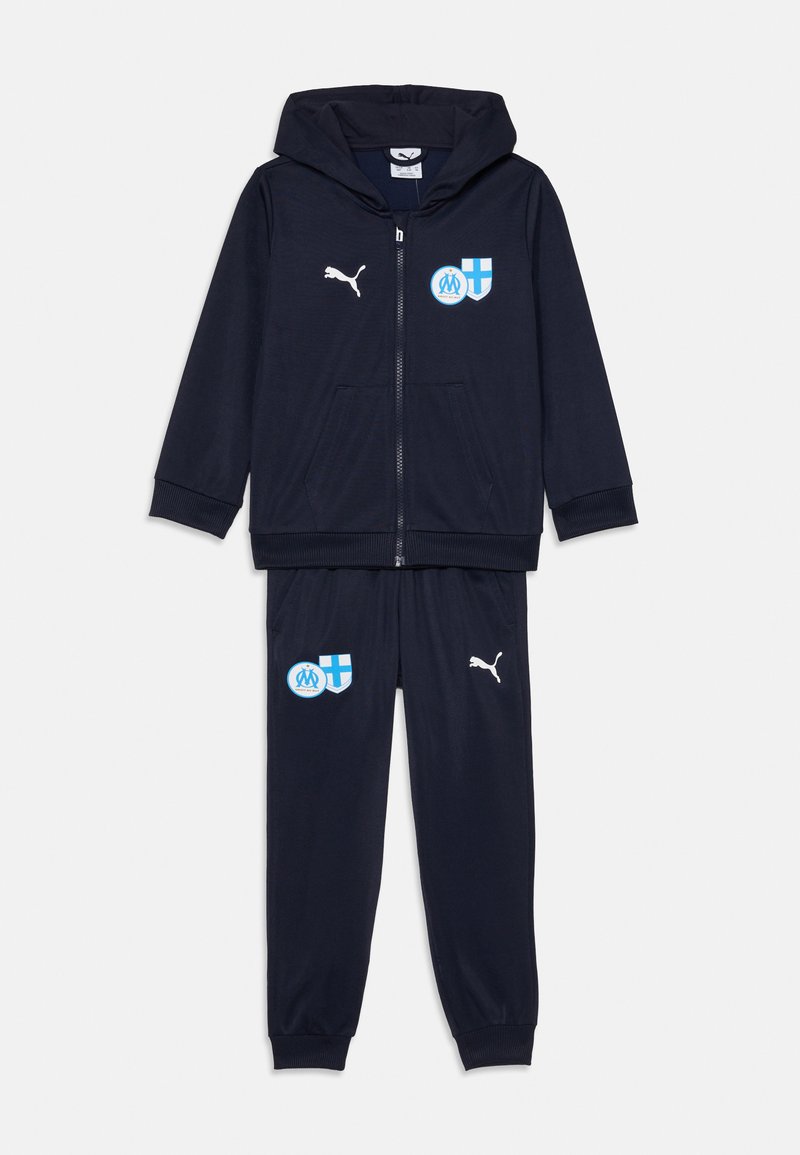 Jūrinis treniruoklių kostiumas, kuriame yra užtrauktuku užsegama gobtuvinė striukė ir elastingo juosmens kelnės, abi su Puma ženklu ir komandos logotipais krūtinėje bei šlaunyje.