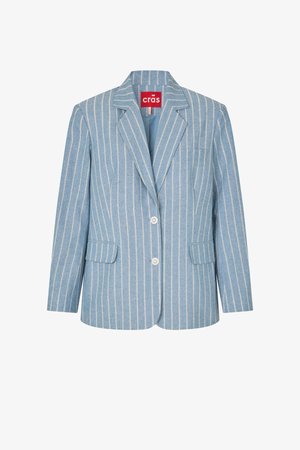 Lyseblå dameskjorte med hvite vertikale nålestriper, to frontlommer med klaff, notchsvinget krage og to knapper foran.