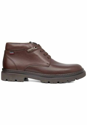 Botas de tobillo de cuero marrón con punta redonda, diseño con cordones y suela resistente. Presenta un acento de costura y un pequeño detalle de logo.