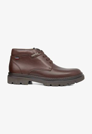 Botas de tobillo de cuero marrón con punta redonda, diseño con cordones y suela resistente. Presenta un acento de costura y un pequeño detalle de logo.