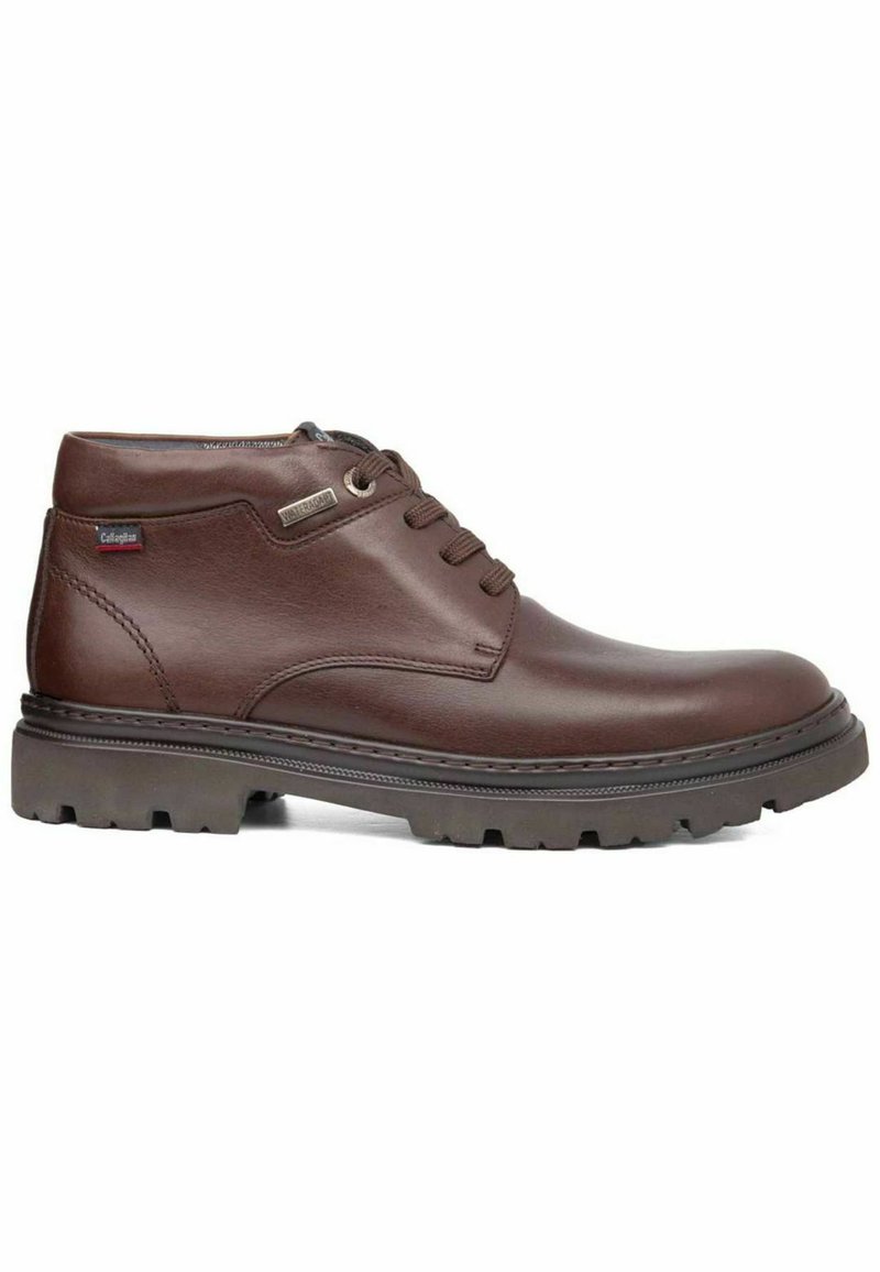 Botas de tobillo de cuero marrón con punta redonda, diseño con cordones y suela resistente. Presenta un acento de costura y un pequeño detalle de logo.