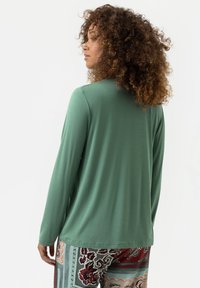 Lange mouwen, mintgroene shirt van zachte stof, met een comfortabele pasvorm en een ronde zoom, gecombineerd met patroonrijke, losse broek.