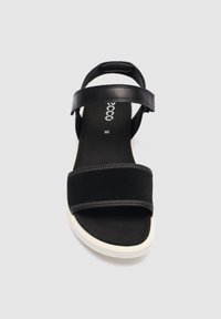 Sandalia negra de punta abierta con correa ajustable en el tobillo, suela blanca y plantilla acolchada, talla 39, vista frontal sobre fondo blanco.